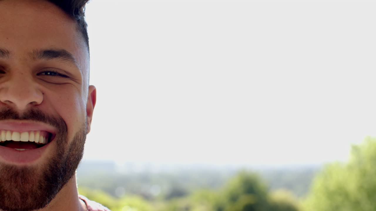 Smiling man outdoors enjoying sunny day, showing happiness and positivity, copy space