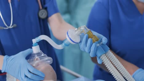 the anesthesiologist in medical gloves prepares female patient for surgery, puts patient into anesthesia, regulates oxygen mask. the nurse administers intravenous anesthesia, intravenous catheter. surgery. anesthesia.