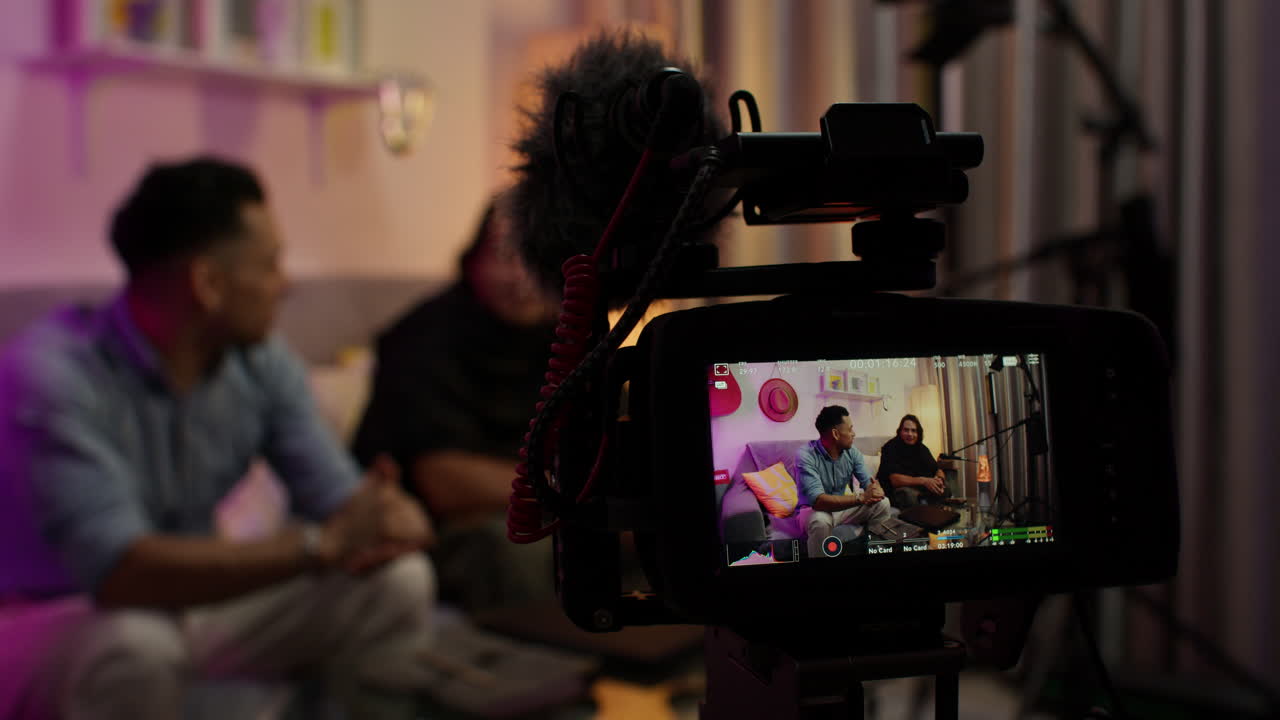 dos bloggers haciendo podcast en vivo desde casa. centrarse en la pantalla de la cámara.