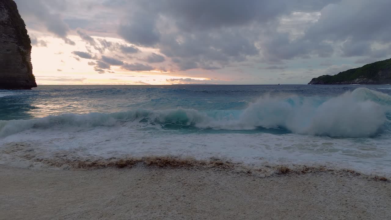 Kelingking Beach i havoverfladen, store bølger ved solnedgang