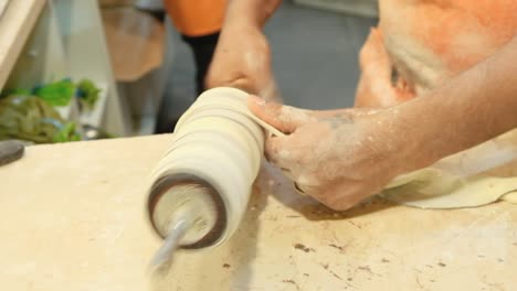 man making pastries in the market. rolling hungarian kiortosh dough