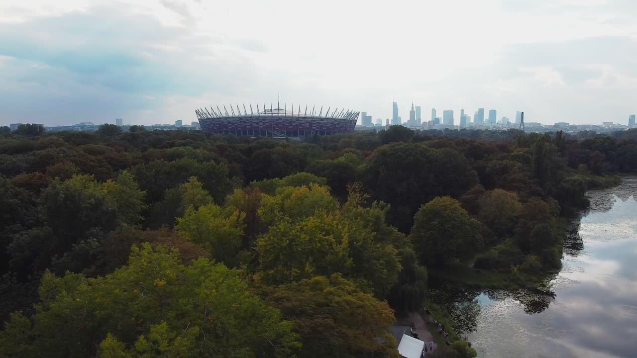 도시 전망, 숲, 호수를 배경으로 한 바르샤바 국립 경기장의 공중 드론 비디오