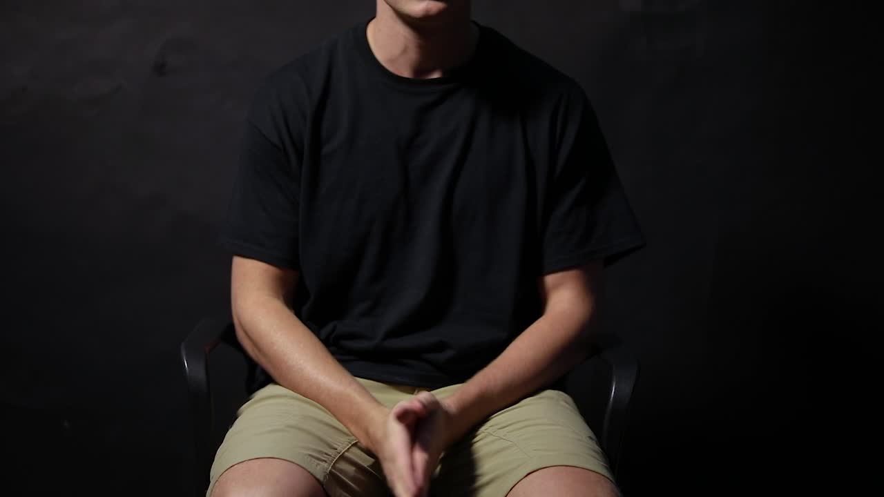 의자에 앉아 불안에 손을 비비고 있는 남자의 사진