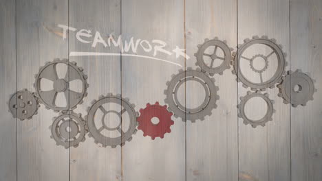 cogs and wheels turning on wooden background