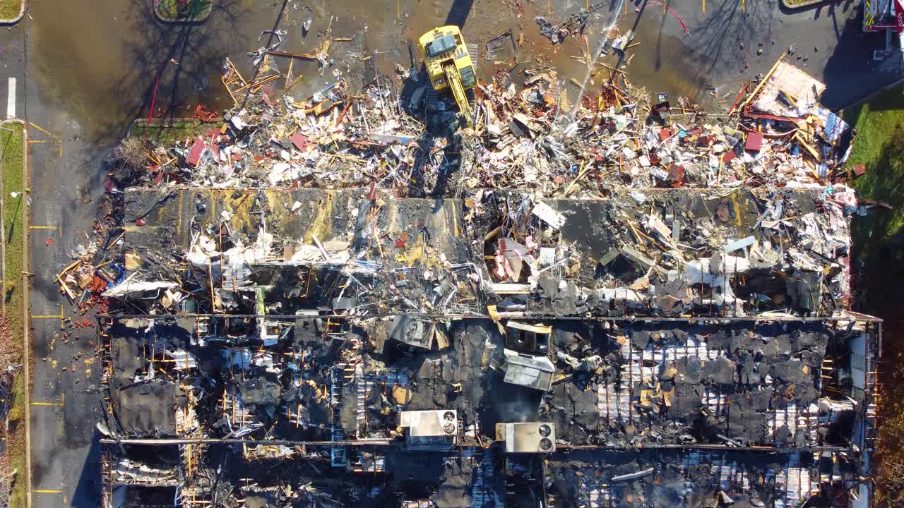 cerrando en un edificio abandonado siendo demolido después de un incendio, amplio, disparo aéreo