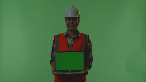 construction worker holding a laptop with green screen