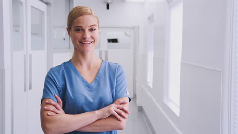 retrato de una doctora sonriente con ropas en el pasillo del hospital