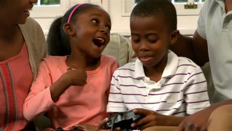 Happy-family-on-sofa-while-son-playing-video-games