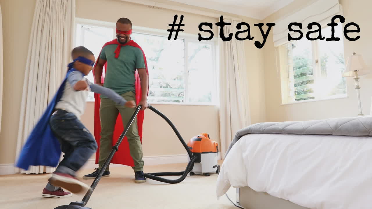Afroameričan a jeho syn v plášti s nápisem „Stay Safe“.
