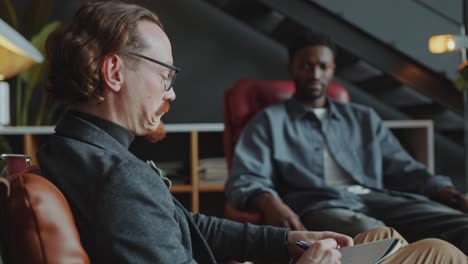 african american man talking with colleague or psychologist in office