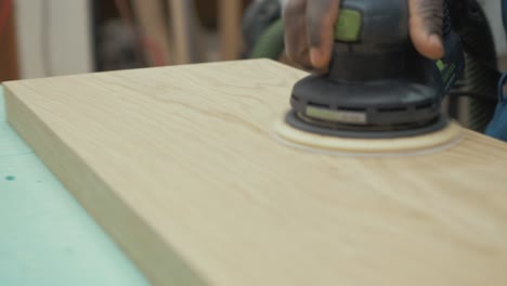 sanding smooth beautiful white oak timber slab with orbital sander