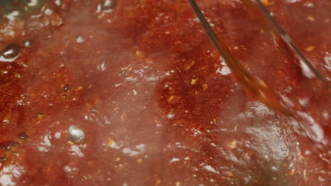 mixing red sauce in a pan