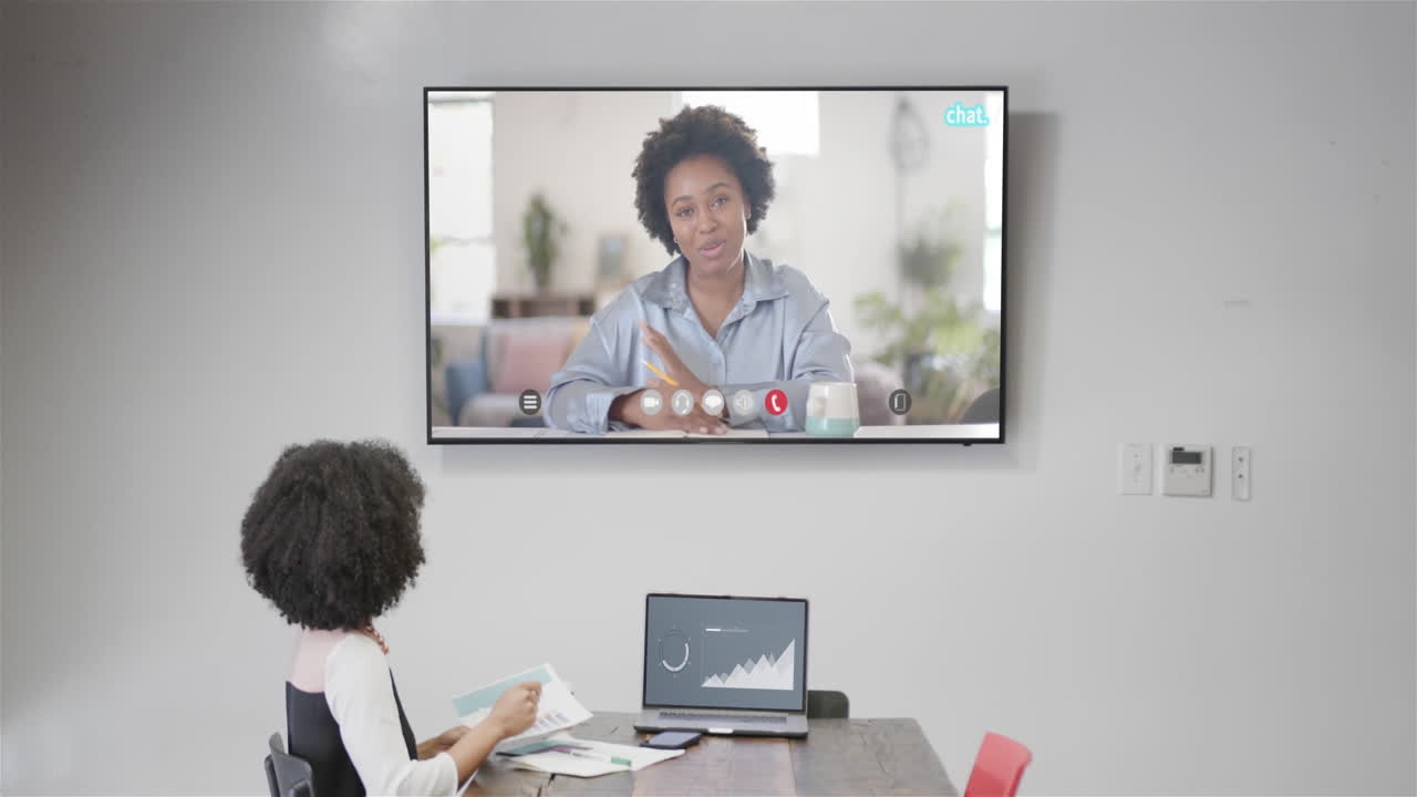 African american businesswoman on video call with african american female colleague on screen