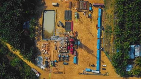 estructura cinematográfica de plataformas de perforación y reacondicionamiento en tierra y equipo de plataformas para la exploración y explotación de petróleo en medio de la jungla rodeada de palmeras durante la puesta de sol