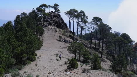 Una-Excursionista-Vestida-De-Amarillo-Lucha-Con-La-Altitud-En-Un-Sendero-De-Montaña-Brumoso