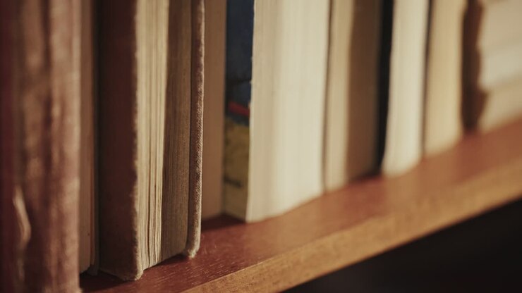 Persona che prende un libro da uno scaffale di legno, ambiente accogliente e tranquillo
