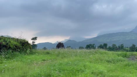 traveling across rural landscape with kalsubai mountain range at background in western ghats, maharashtra india
