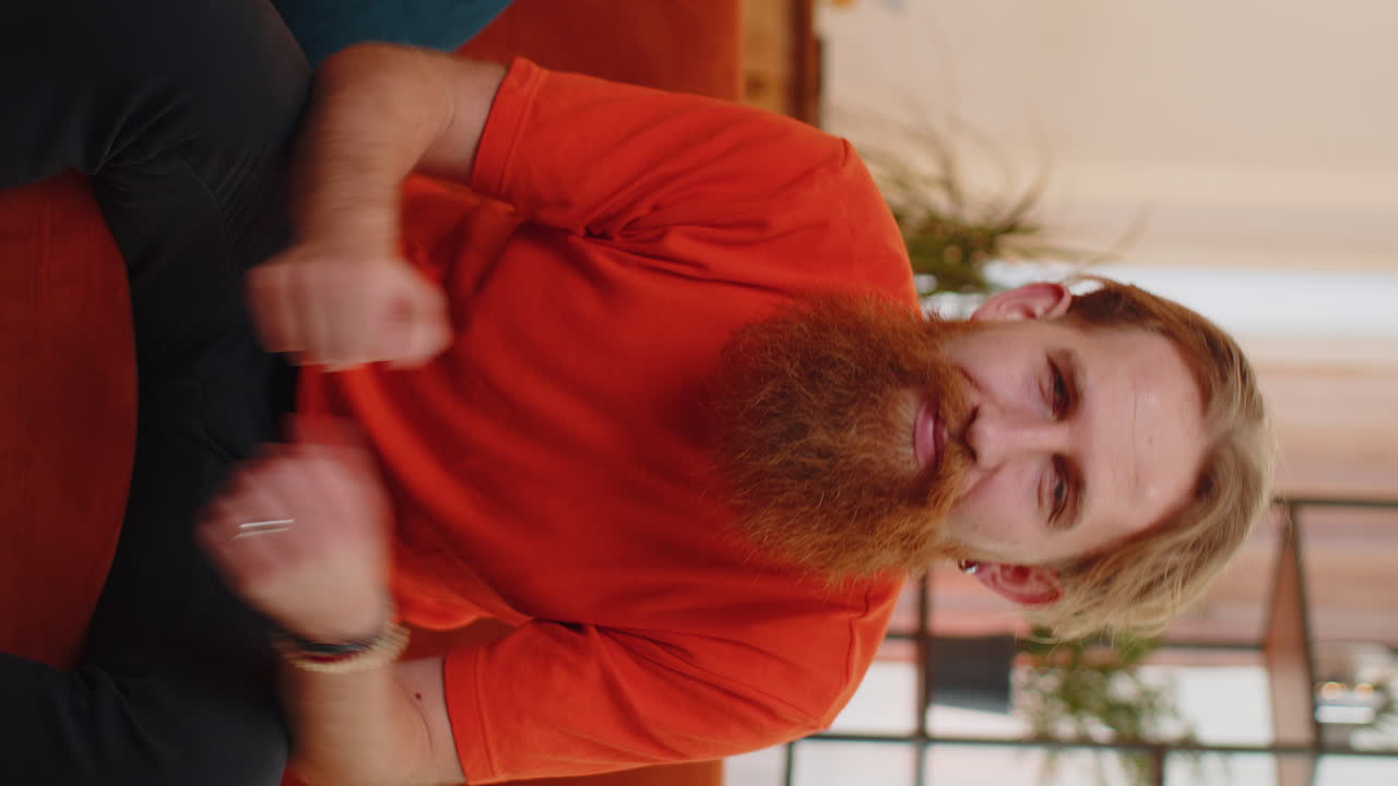 joven feliz mirando con aprobación a la cámara mostrando los pulgares hacia arriba, como un signo positivo, buenas noticias