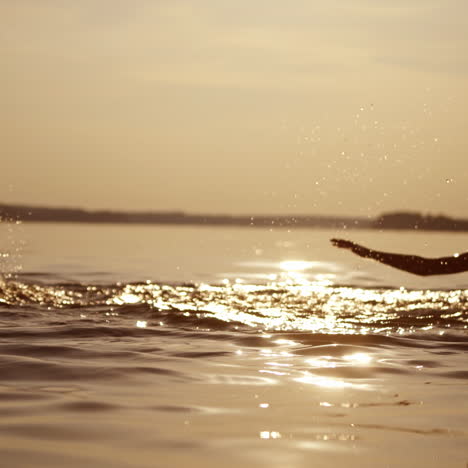 happy boys are jumping and making splashes in water at sunset. silhouette of two cheerful brothers having fun in water in the evening. summer fun.