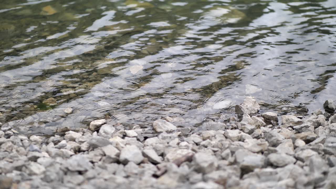 Beautiful clear freshwater by the rocky riverbank in Obersee Switzerland - close up