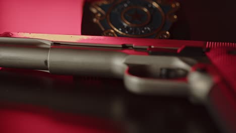 panning over firearm with a police badge in the background