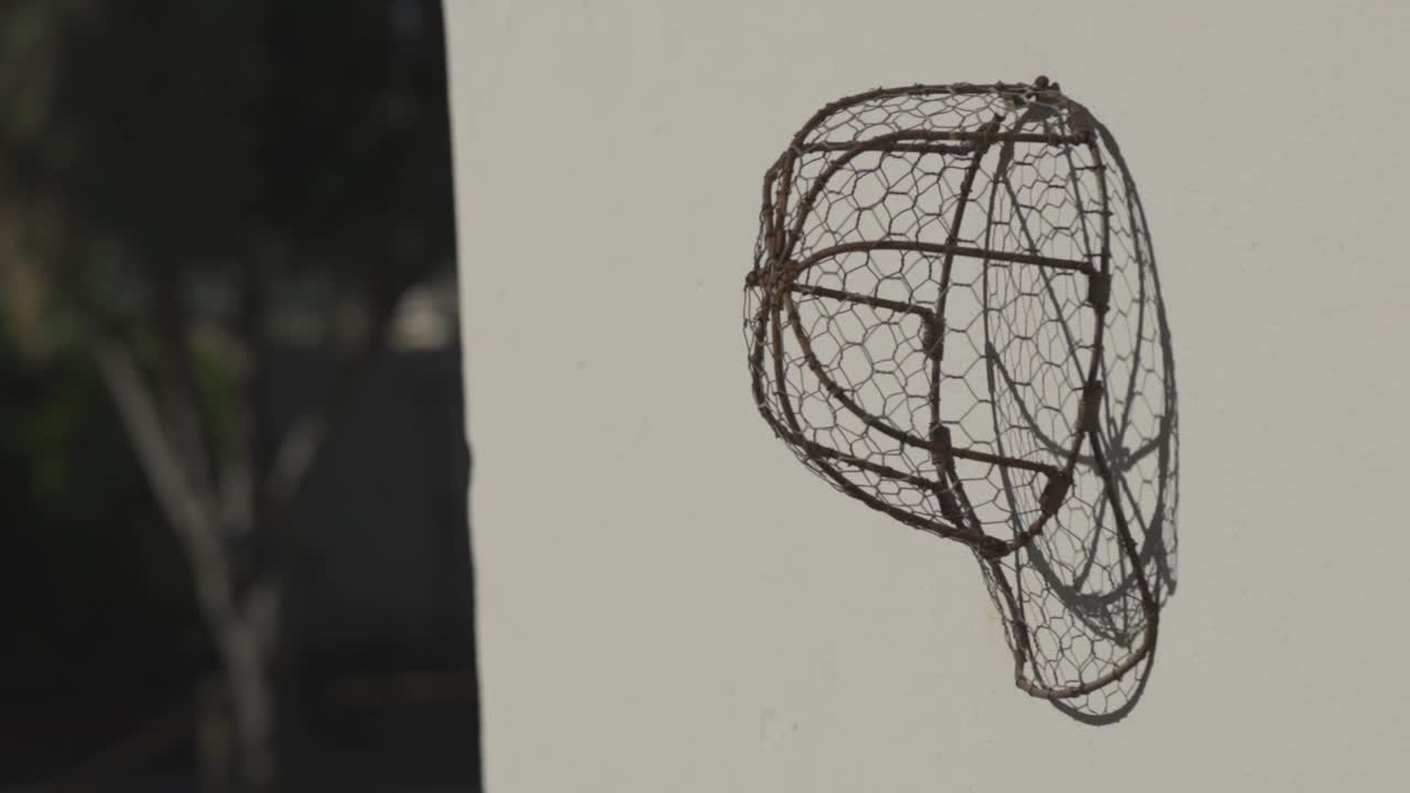 벽에 걸려있는 강철 와이어 프레임 모자