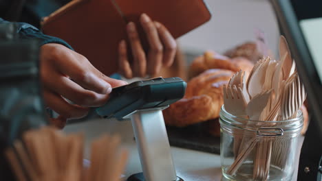 close up customer paying using credit card contactless payment spending money in cafe with digital transaction service