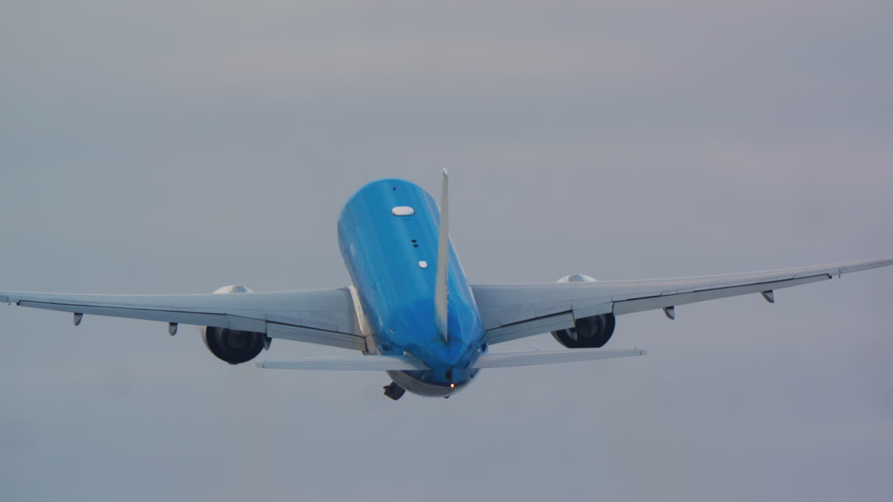 Grande aereo passeggeri blu in decollo verso un cielo nuvoloso