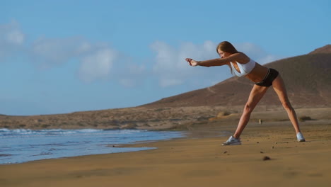 Mujer-Estirando-Las-Piernas-Y-Los-Isquiotibiales-Haciendo-Posición-De-Estiramiento-De-Yoga-De-Flexión-Hacia-Adelante-En-La-Playa-Fitness-Mujer-Relajante-Y-Practicando-Deporte-Y-Yoga.