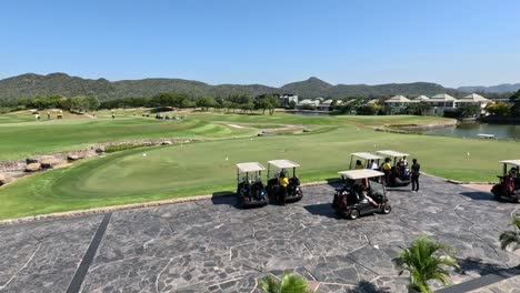 golf carts moving across a picturesque course