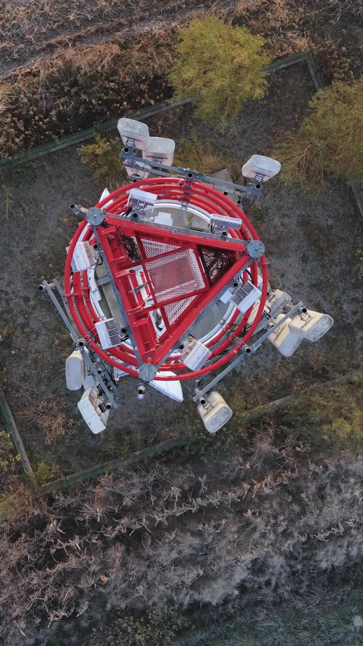 Vista aerea verticale dall'alto di una torre di telecomunicazioni 5G. Moderna infrastruttura e connettività di tecnologia wireless