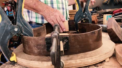 Guitar-Artisan-Klemmt-Den-Gitarrenkörper-Fest,-Um-Ihn-An-Ort-Und-Stelle-Zu-Halten