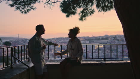 carefree couple dating on evening viewpoint at sunset. dark silhouettes people