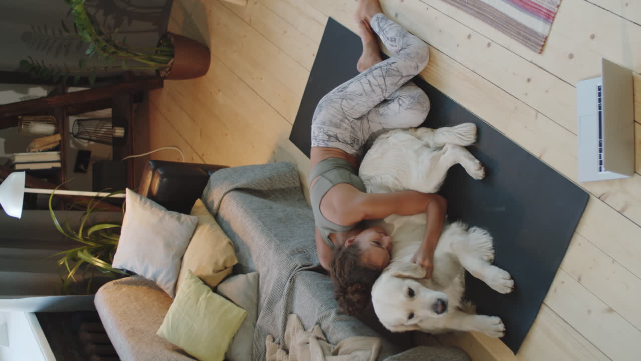 요가 매트 에 있는 개 와 함께 휴식 하는 여자