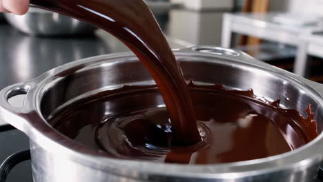 pouring melted chocolate into a pot