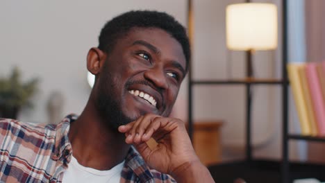 happy calm young african american bearded man smiling looking away dreaming resting feel satisfied