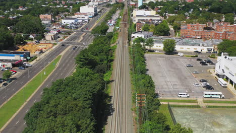 slow-flight-over-Long-Island-Railroad-tracks,-trees---Sunrise-Highway-in-Rockville-Centre,-New-York