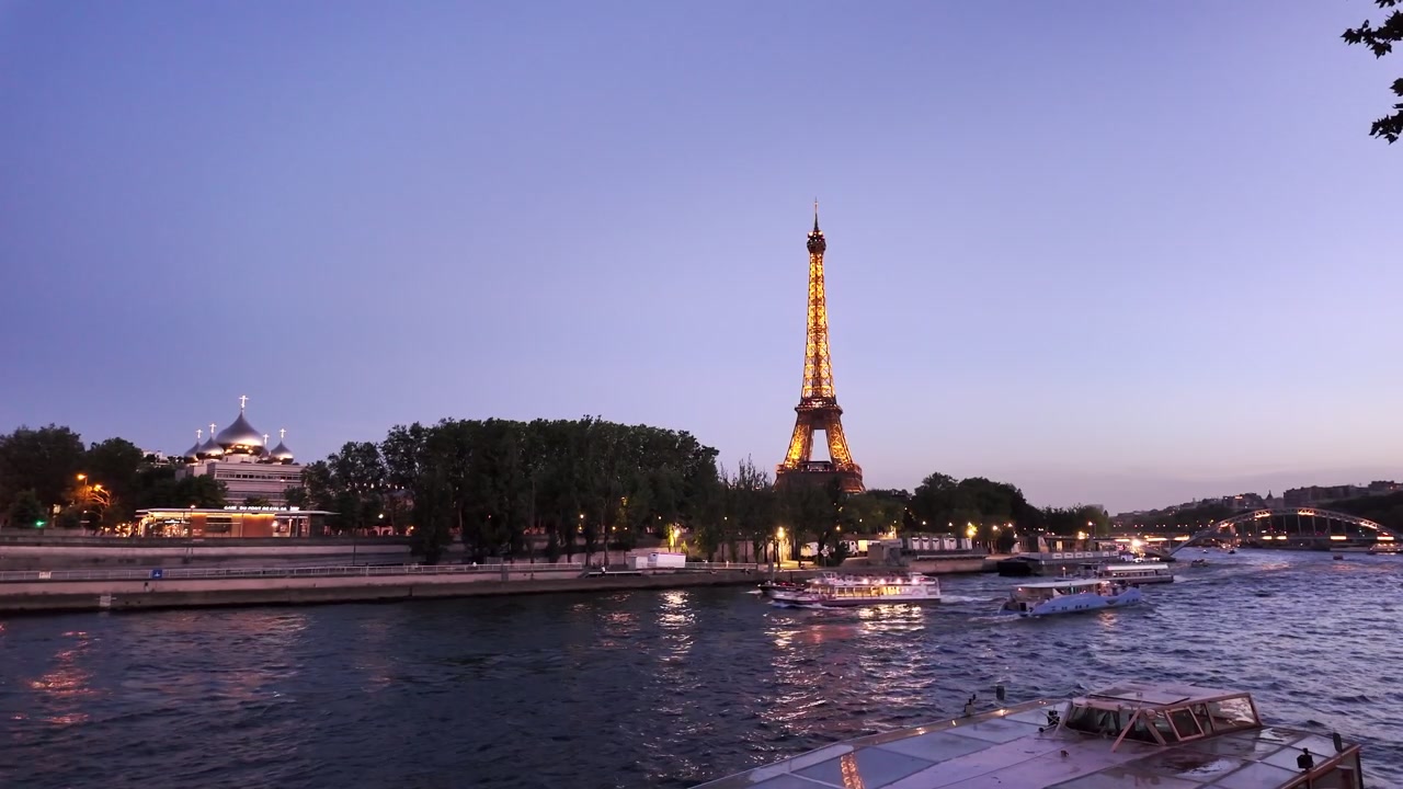 Torre Eiffel illuminata sopra il fiume Senna all'ora blu a Parigi.