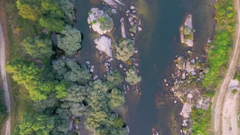 Top-View-Of-Freshwater-River-Flowing-With-Vegetation-In-Nature-Park