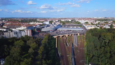 Dramatic-aerial-top-view-flight-suburban-train-tracks-Platform-yellow-S-Bahn-Station-bridge,-Berlin-mitte-summer-2023