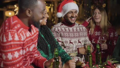 Plano-Medio-De-Amigos-Celebrando-La-Navidad-En-Un-Bar.