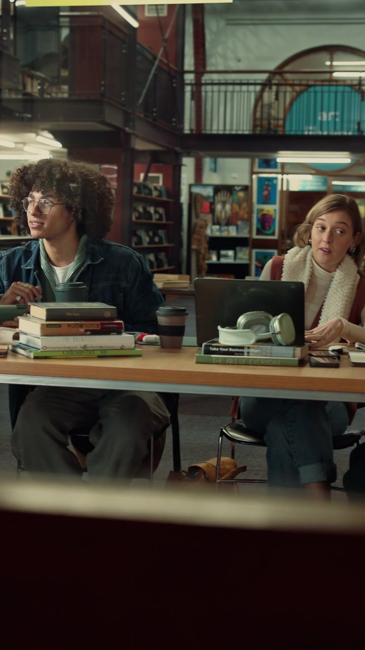 Studenti di diverse etnie che collaborano a un progetto in biblioteca