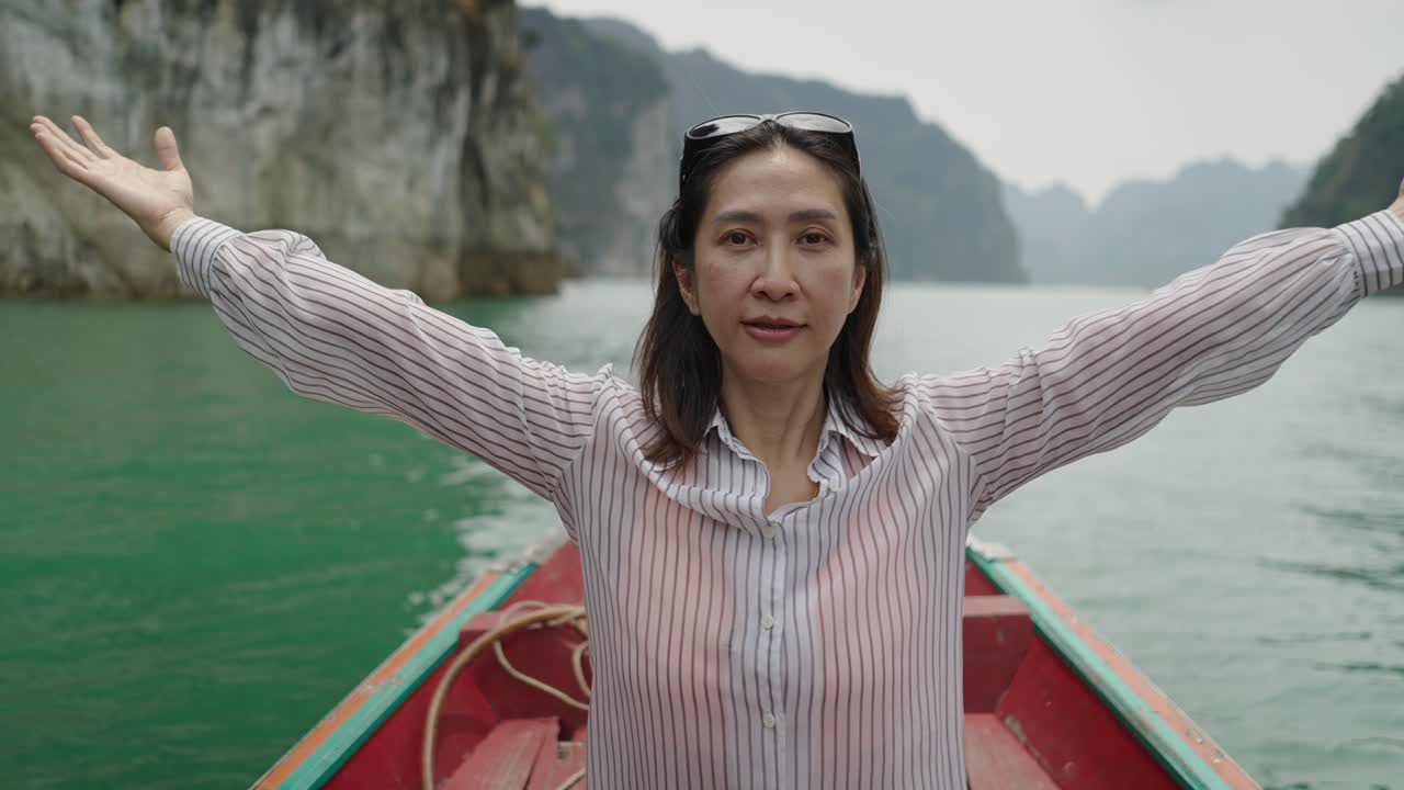 Woman on a boat embracing the serene nature of a mountain lake