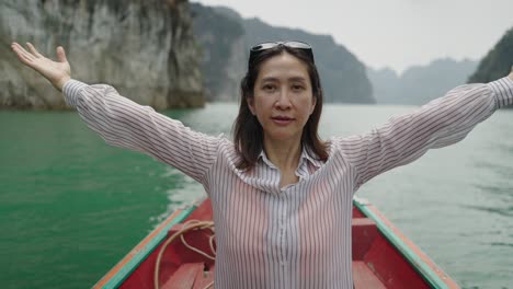 woman on a boat embracing the serene nature of a mountain lake