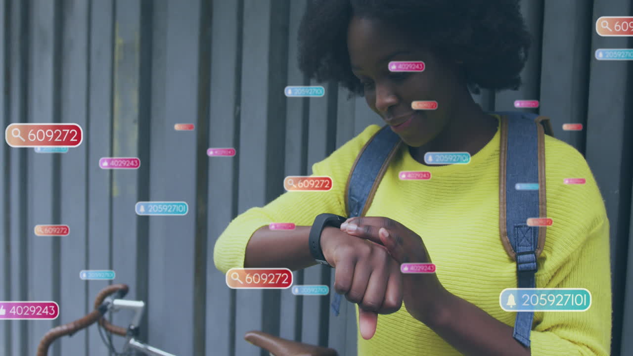 Animation of social media icons and data over african american woman using smartwatch