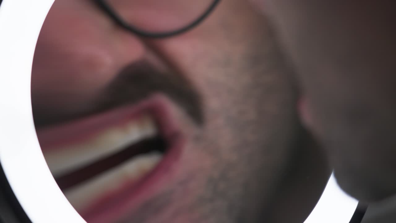 A man checking his face in the ring light mirror