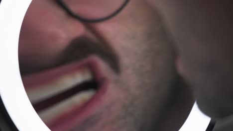 a man checking his face in the ring light mirror