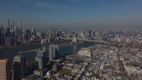 Aerial-panoramic-view-of-development-in-large-city.-Manhattan,-Queens-and-Queensboro-Bridge-over-river-between.-New-York-City,-USA