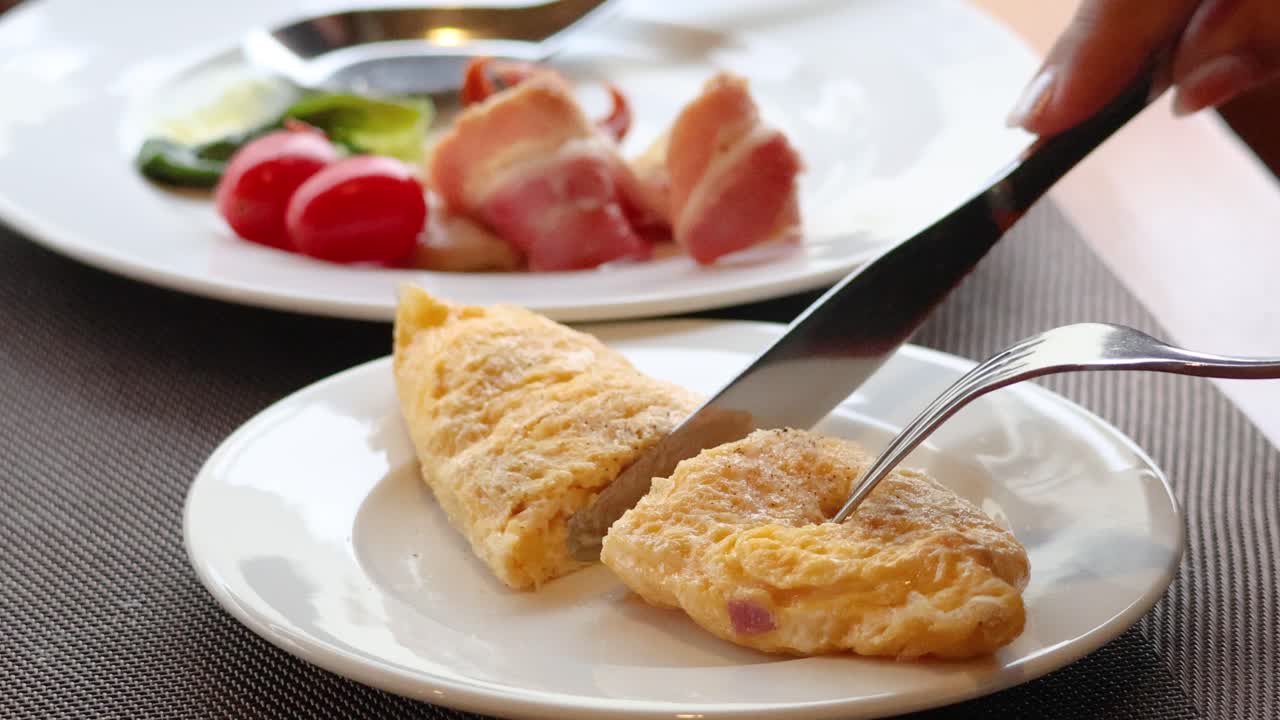 Tagliare un'omelette soffice su un piatto.