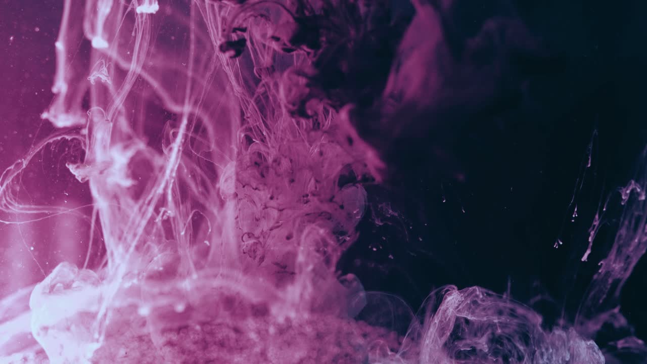 поток разноцветных чернил и краски, подводный черный фон, вливание смеси